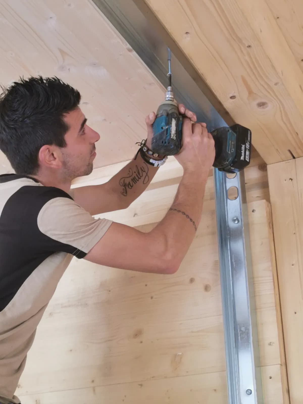 Operaio installa componenti su parete in legno lamellare